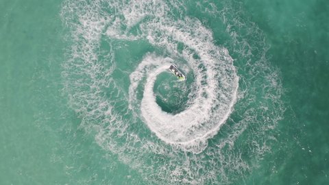 Aerial top view of water craft or boat drawing a shape on sea ocean turquoise water. Adventure outdoor extreme recreation activity in summer season. Lifestyle