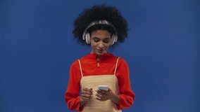 happy african american girl listening music isolated on blue