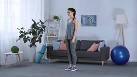 Side view of sportswoman doing lunge while training at home