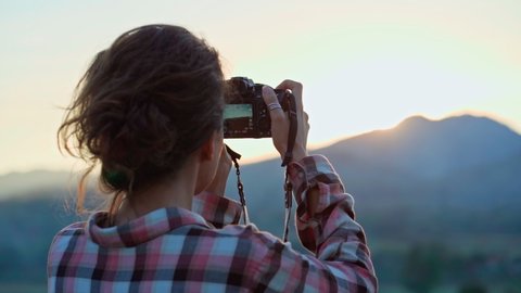 photographer, taking pictures of mountain landscape at sunset