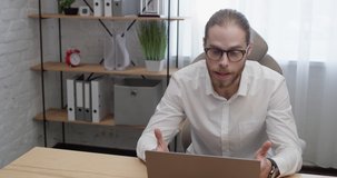 Attractive Businessman wears Eyeglasses Talking by Laptop Webcam with Partners. Successful Bearded Man holding a Video - Conference with Employees of the Company. Smart Management. Distant.