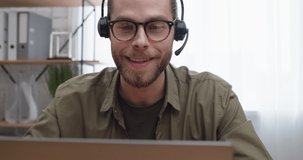 Professional Young Man Teacher wearing Headset holding Online Lesson. Attractive Male Looking at Laptop Screen Talking with a Student sitting at Home Remote. Distant Learning. Improve Knowledge.