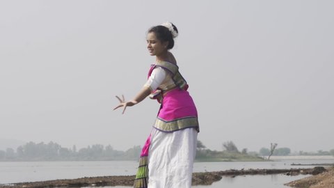 A bharatnatyam dancer displaying a classical bharatnatyam pose in the nature of  Vadatalav lake, Pavagadh. Beautiful indian girl dancer in the posture of Indian classical dance bharatanatyam .