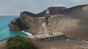 Drone shot of lighthouse of Ponta dos Capelinhos, Faial Island, Azores, Portugal, Europe. Volcano Interpretation Center of Capelinhos located at athlantic ocean at sunset, 4k footage