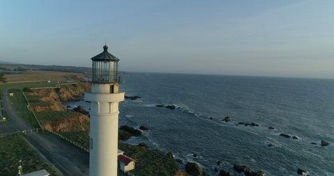 Lighthouse on the pacific coast from above, Point Arena, California coast line, aerial view of ocean waves, cliffs and rocks at Point Arena Mendocino County, United States, sunset windy day