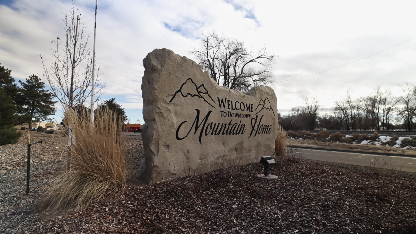 Moving in to the Welcome to Downtown Mountain Home sign in Idaho as a car drives by.