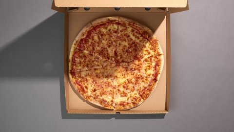 Top view of delivering a pizza box. Pizza slices disappear. Stop motion animation.