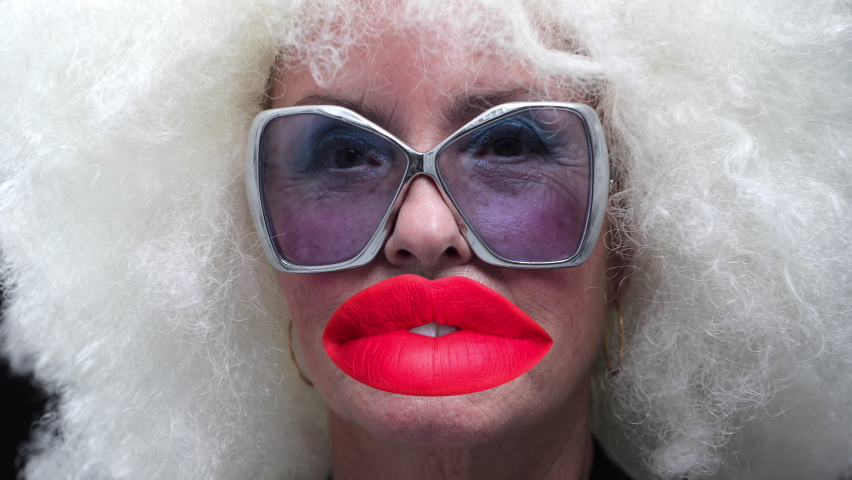 Retro grandma with large sunglasses and white afro hair talking with oversized lips