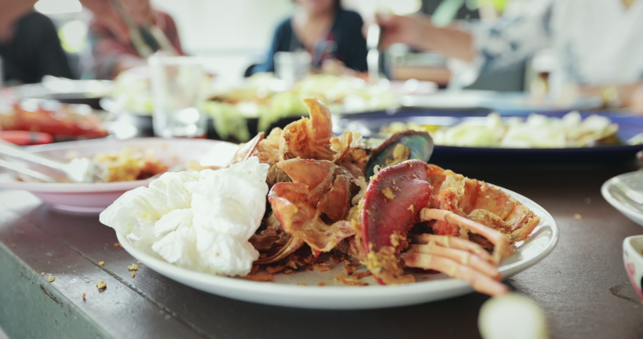 Dirty waste food and used napkin on plate after eating seafood party in the restaurant. Slow motion shot. Royalty-Free Stock Footage #1069621837