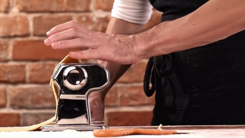 Preparing home made pasta with pasta maker. Chef use pasta cutting machine. 