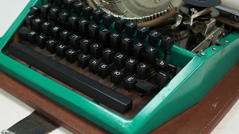 Isolated vintage typewriter keyboard. Slow dolly across type writer keys. Macro shot of retro typewriter keys. typewriter and novel book on table. Romantic macro shot. Underwood typewriter