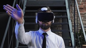 A man office manager in formal clothing wearing virtual reality vr glasses swiping scrolling online images in modern office. Augmented reality concept. People and technology.