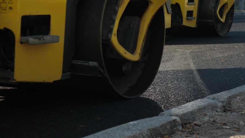 Making new asphalt at road construction. Paver or paving machine lay bitumen. Rollers levele and compact new asphalt. Road surface repair. Construction of new road Royalty-Free Stock Footage #1069626649