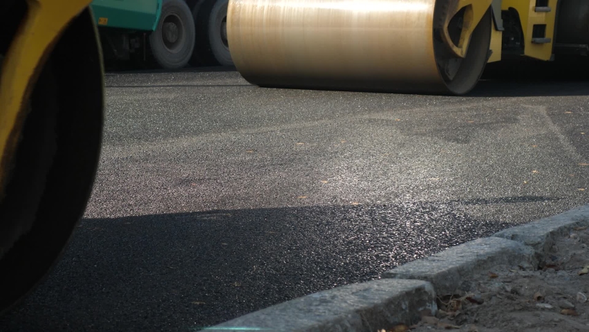 Making new asphalt at road construction. Paver or paving machine lay bitumen. Rollers levele and compact new asphalt. Road surface repair. Construction of new road | Shutterstock HD Video #1069626649