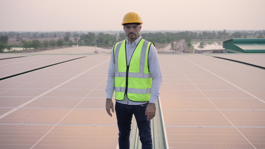 Portrait of confident engineer of solar cell farm industry, Worker standing on solar cell wearing safety vest with eyeglass protection crossing arms. Staff confident pose Solar cell panel installation