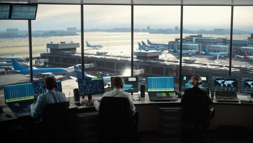 Diverse Air Traffic Control Team Working in a Modern Airport Tower. Office Room is Full of Desktop Computer Displays with Navigation Screens, Airplane Departure and Arrival Data for Controllers. Royalty-Free Stock Footage #1069631446