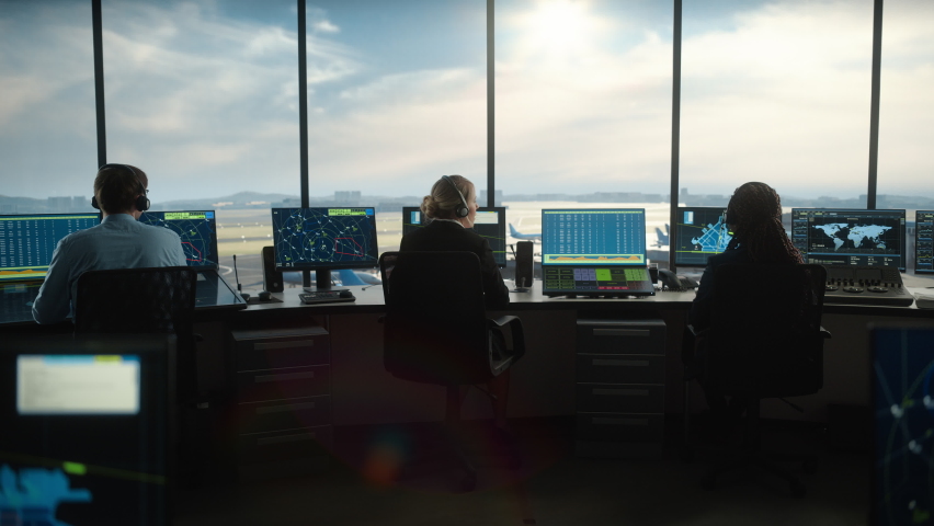 Diverse Air Traffic Control Team Working in a Modern Airport Tower. Office Room is Full of Desktop Computer Displays with Navigation Screens, Airplane Departure and Arrival Data for Controllers. | Shutterstock HD Video #1069631452