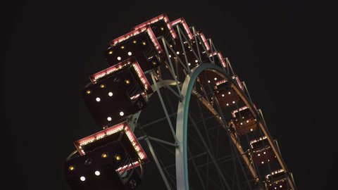 Bright ferris wheel turning spinning at night at a amusement park. Vídeo Stock