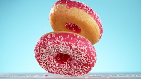 Delicious donut falls on pastel background. Super Slow motion