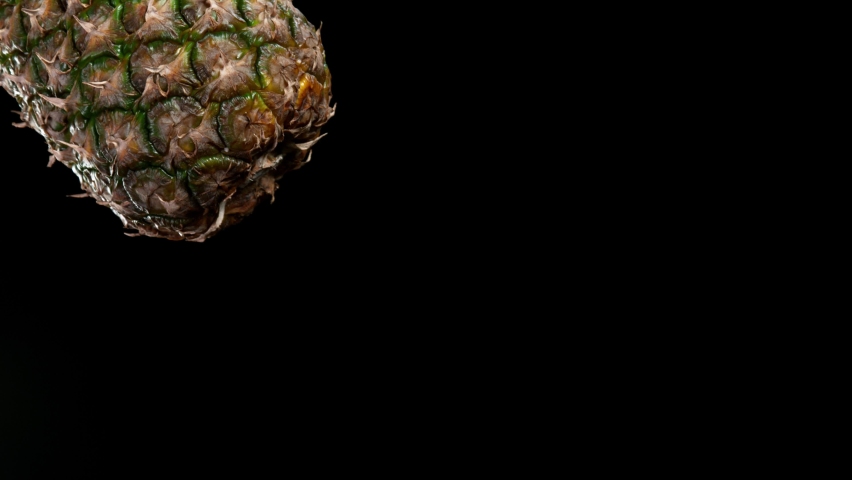 Super slow motion of cutting flying pineapple