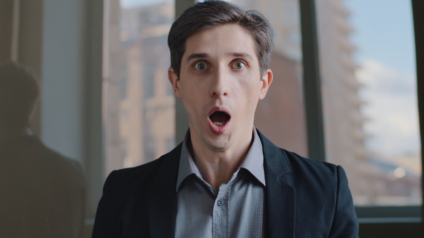Portrait of Caucasian shocked business man entrepreneur looking at camera opens mouth wide in surprise of unexpected win, shouts. Close-up employee with expression of horror, fear sitting in office | Shutterstock HD Video #1069646152