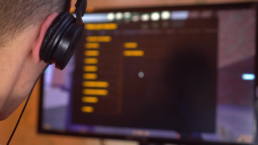 A gamer with headphones in the room is playing a video game. Quarantine or game competitions. Cyber competition.