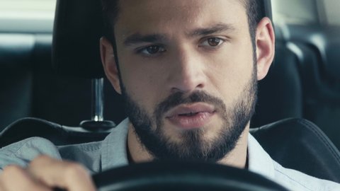 selective focus of sweaty bearded man holding steering wheel and driving car