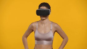 Smiling sportswoman in vr headset jogging isolated on yellow