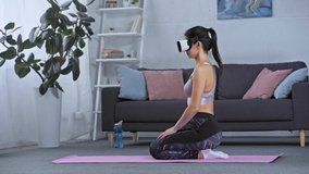 Side view of sportswoman in vr headset training at home