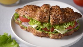 Croissant sandwich with meat, vegetables and cheese white background. Breakfast food concept.
