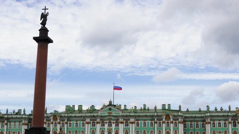 Alexander Column beyond Hermitage Museum in Saint-Petersburg on summer cloudy day. Clouds float across the blue sky above the Hermitage