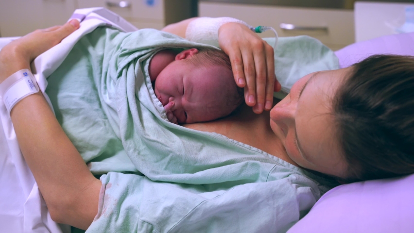 Mother and newborn. Child birth in maternity hospital. Young mom hugging her newborn baby after delivery. Woman giving birth. First moments of baby life after labor. Royalty-Free Stock Footage #1069668487