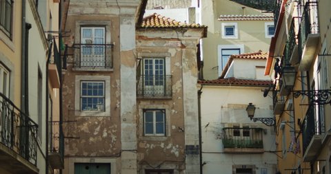 Old apartment building in Lisbon, Portugal with cracked plaster on the walls. Slow motion.