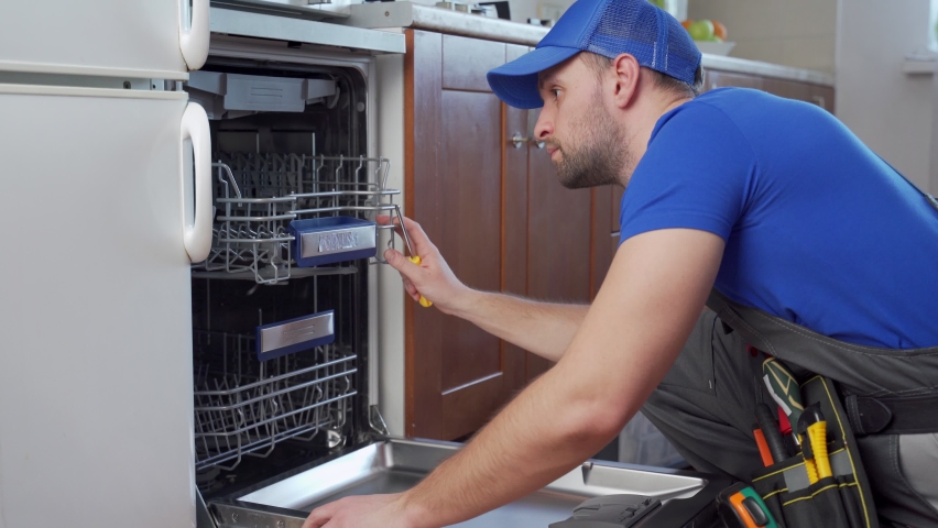 Repair of dishwashers. Repairman repairing dishwasher in kitchen Royalty-Free Stock Footage #1069681576