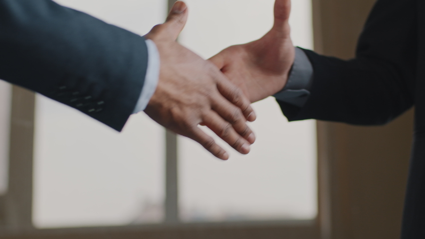 Close up male hands multiethnic business men african and caucasian colleagues in suit handshake in office. Unrecognizable employer hire ethnic vacancy candidate shakes hands, makes congratulations  Royalty-Free Stock Footage #1069691884
