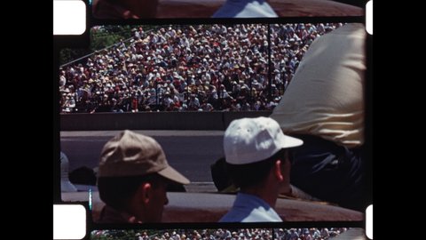 1950s Indianapolis, IN. View from Infield of Indianapolis Motor Speedway during Indianapolis 500. Race Cars Speed past Spectators. 4K Overscan of Vintage Archival 16mm Film Print
