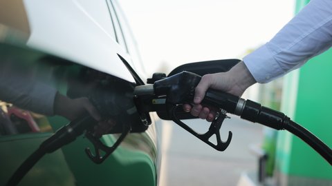 Filling car with gas fuel at station pump. Car filling up with fuel. Diesel Oil. Gas nozzle in car's fuel tank. Fuel, gas station, petrol prices concept.