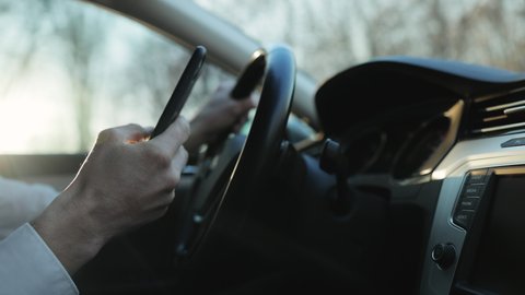 Man Texting On Smartphone While Driving Car. Checking Email Chats And Reading News. Male Writing Message In Vehicle On Social Network Chats On Cellphone. Texting And Driving Car On Social Media