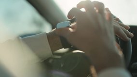 Close-up male hands using modern smart watch inside car. Life of a businessman. Man watch notification. Male hand with a smart watch holds the steering wheel. - Powered by Shutterstock - Get 15% off with code: PIKWIZARD15