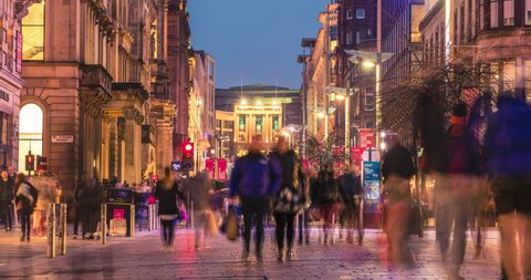 Glasgow, Scotland - February 15, 2019: timelapse of pedestrians walking along the brightly lit Buchanan street in the city centre at night
