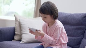 Asian kids using smartphones at home