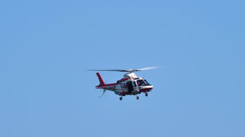 Jesolo, Italy 09.15.2019 - AugustaWestland AW109 rescue firefighters helicopter flies over blue sky. Sea rescue drill. High quality 4k footage