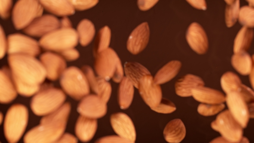 Super Slow Motion Shot of Almonds Falling into Melted Chocolate at 1000 fps. Royalty-Free Stock Footage #1069718239