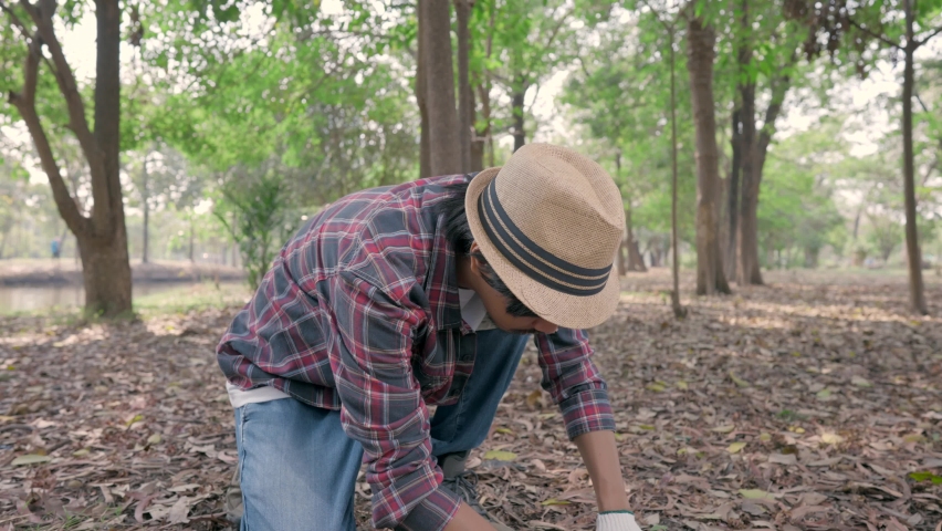 Asia man plant sapling tree in garden
