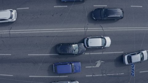 Two cars accident - top view drone shot of two crushed cars on the road. Cars go around the scene of an accident.