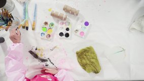 Time lapse. Flat lay. Kids papercraft. Painting empty toilet paper rolls with acrylic paint to create paper bugs.