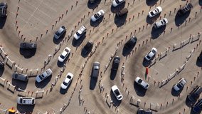 Aerial shot of 1000’s of people in cars waiting in line at a drive-through testing site to be tested for Coronavirus or to receive the vaccine. - Powered by Shutterstock - Get 15% off with code: PIKWIZARD15