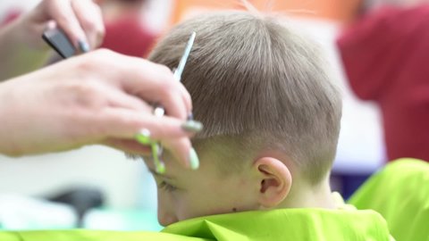Close-up portrait of a cute handsome teenager boy sitting barbershop getting his head shaved vintage style haircut professional hairdresser hairstylist barber. healthcare lifestyle