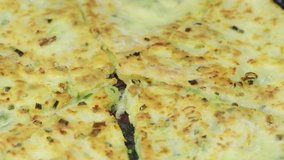 Onion cheese cakes. Homemade cheese, green onions and bacon flatbread. Flatbread with onion cheese and beacon fried in a pan close-up.