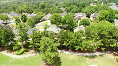 Aerial video shot in 4k over an upscale housing cluster in a beautiful sub division in suburbs during early spring with fresh foliage on trees and plants